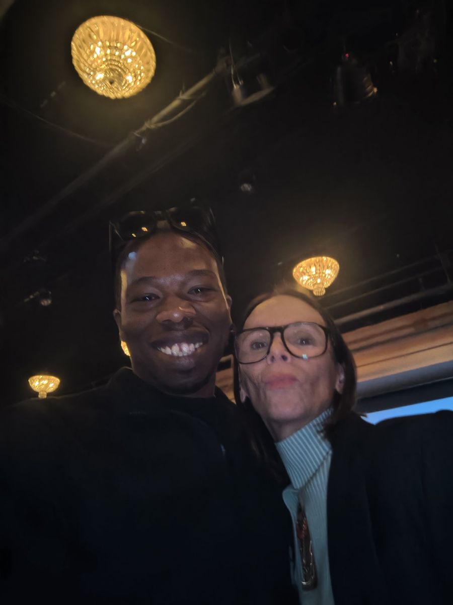 Jamel Miller smiling with a community partner at an evening event