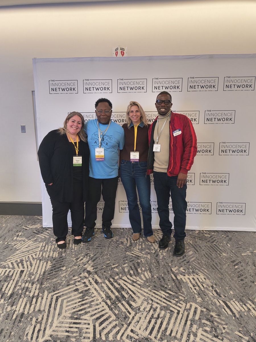 Jamel Miller with three colleagues in front of The Innocence Network conference backdrop in Chicago