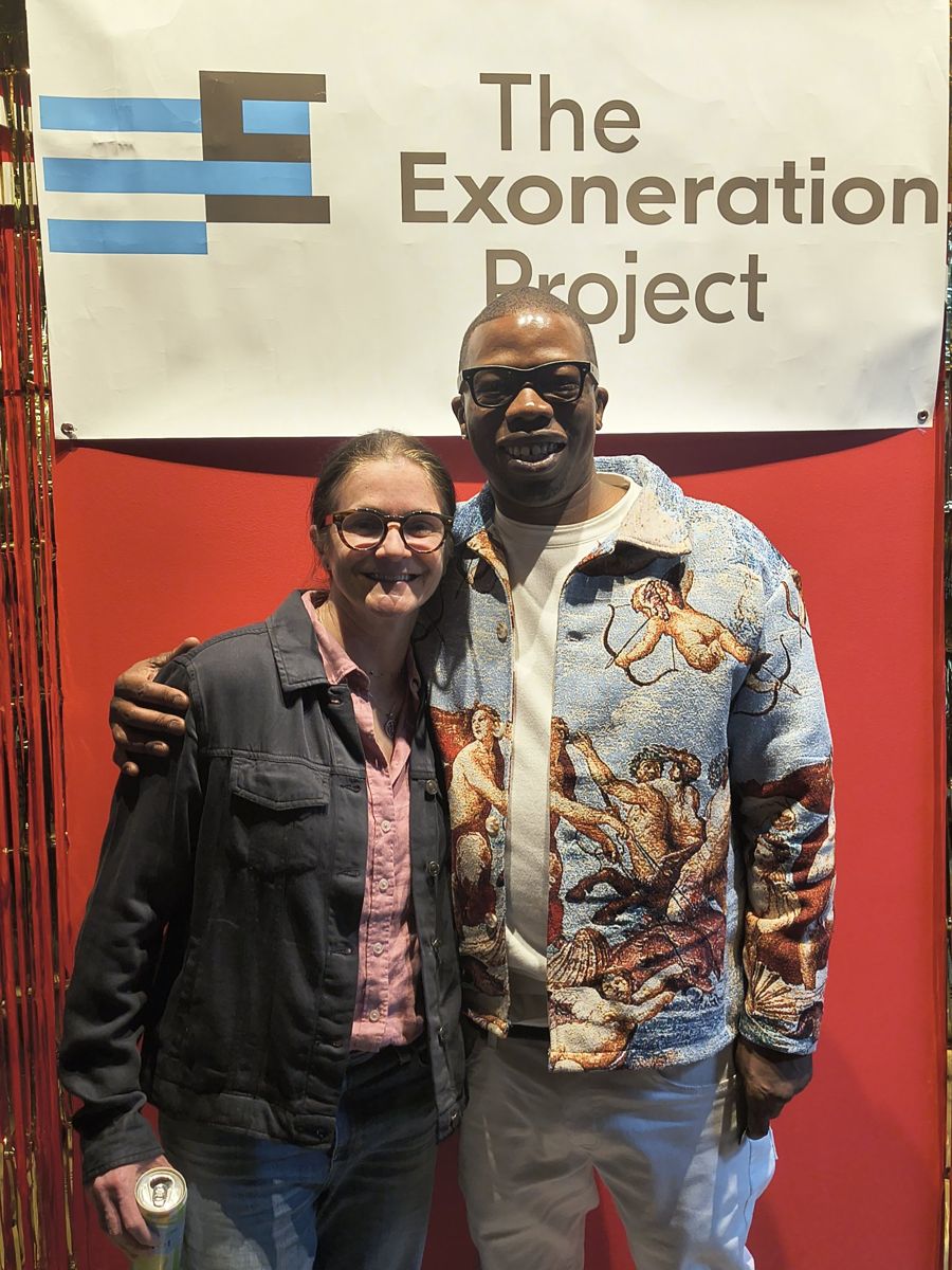 Jamel Miller with a colleague in front of The Exoneration Project banner